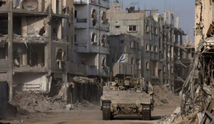 Sebuah kendaraan lapis baja melaju sementara bangunan-bangunan yang rusak terlihat di latar belakang, di tengah operasi darat yang sedang berlangsung oleh tentara Israel melawan kelompok Islamis Palestina, Hamas, di Jalur Gaza, 13 September 2024. REUTERS/Amir Cohen