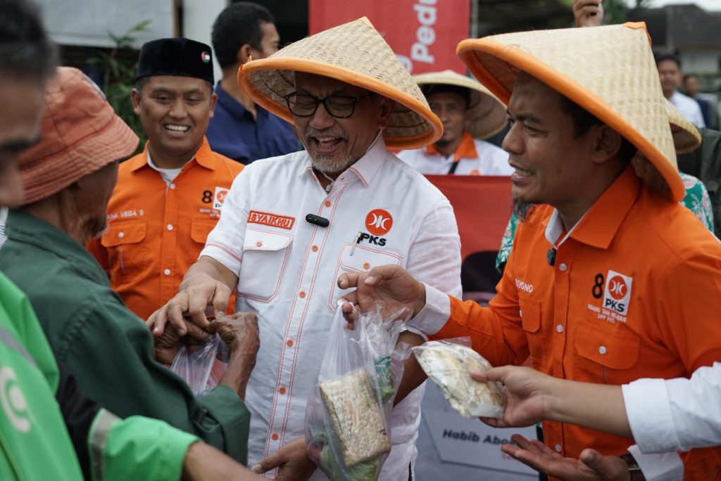 Ketua DPP PKS Bidang Tani dan Nelayan, Riyono Caping dan Presiden PKS Ahmad Syaikhu dalam aksi berbagi 1.000 paket sayuran dan 300 paket ikan asin kepada masyarakat di sekitar kantor DPTP PKS, Jakarta Selatan, Rabu (19/3/2025).