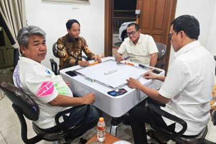 Raja Juli saat bermain domino bersama tersangka pembalakan liar, Aziz Wellang.